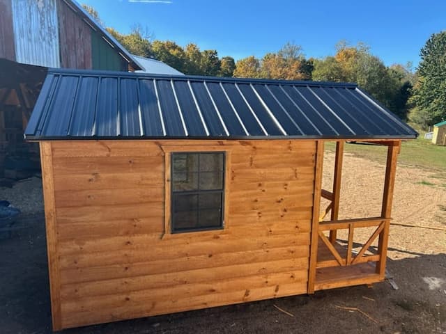 Side exterior view of a cabin-style tiny home on a trailer
